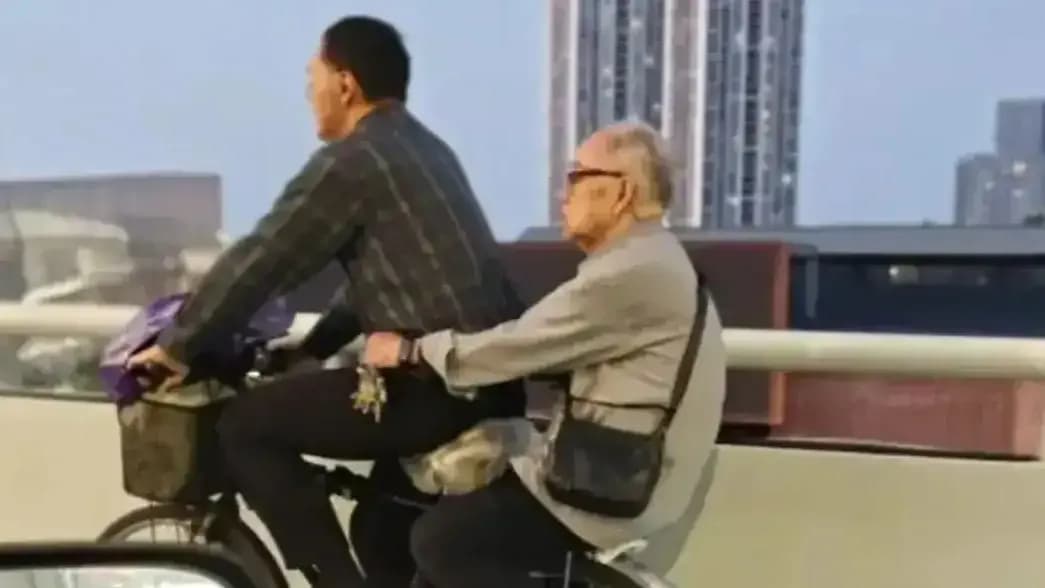 看见中年男子骑车载白发老人，拍摄者想起去年过世的父亲